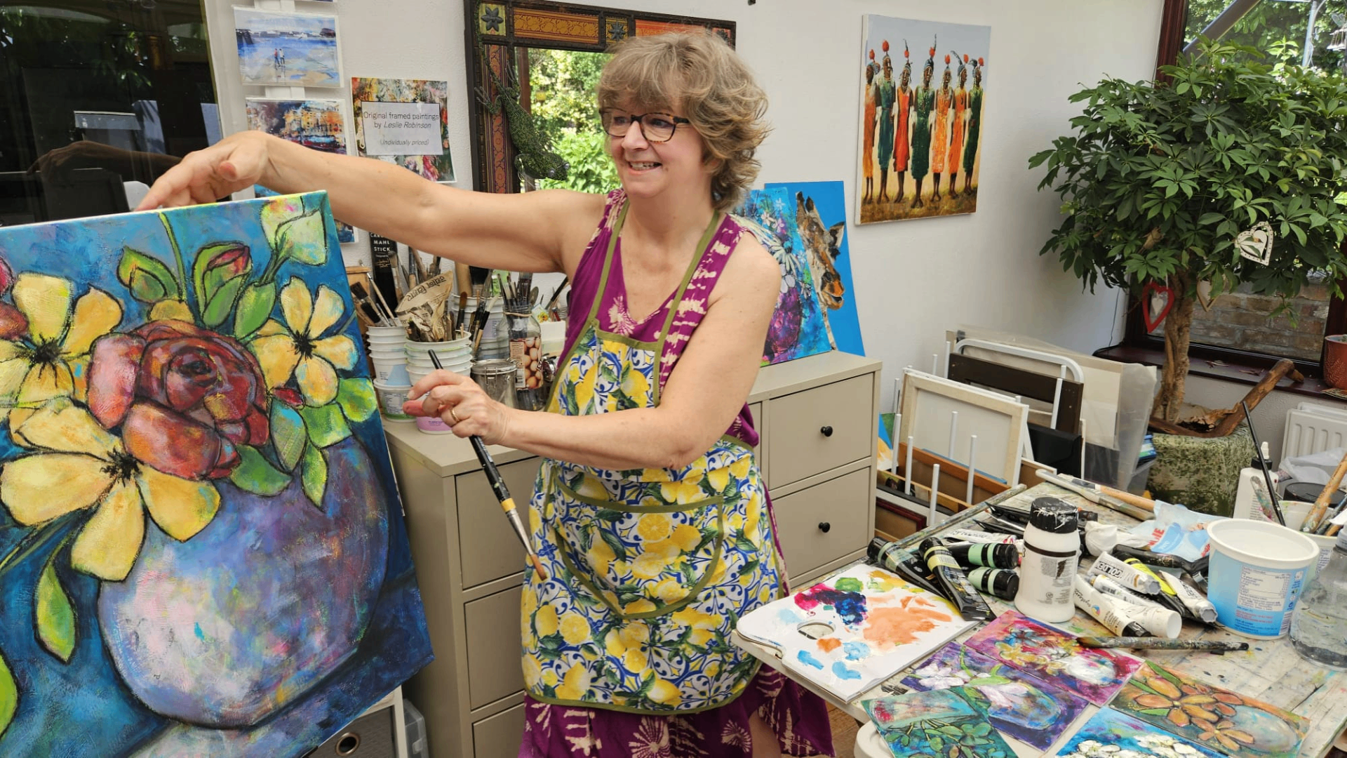 A floral painting in progress on the studio easel